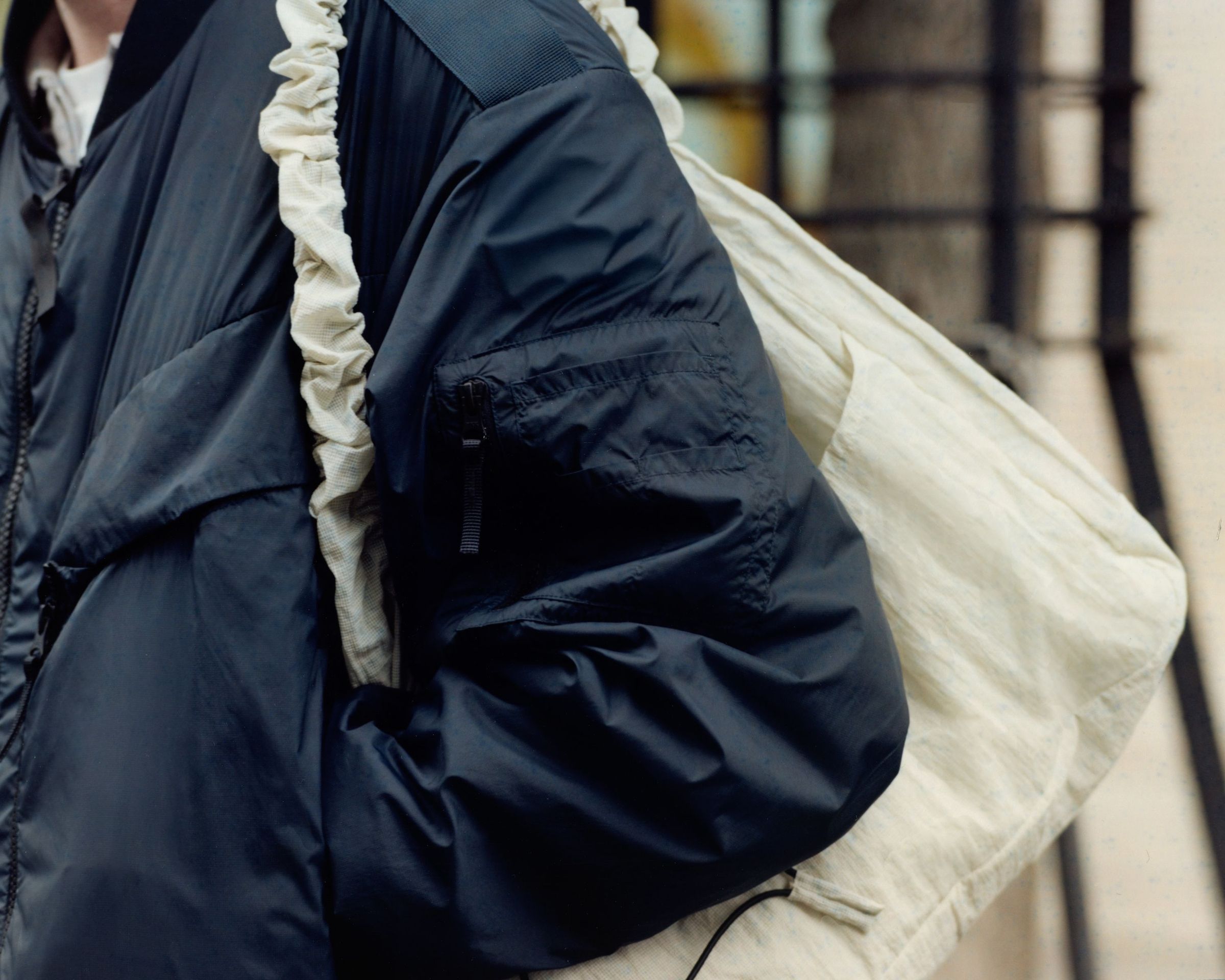 Air Carrier bag worn over the shoulder with a navy jacket